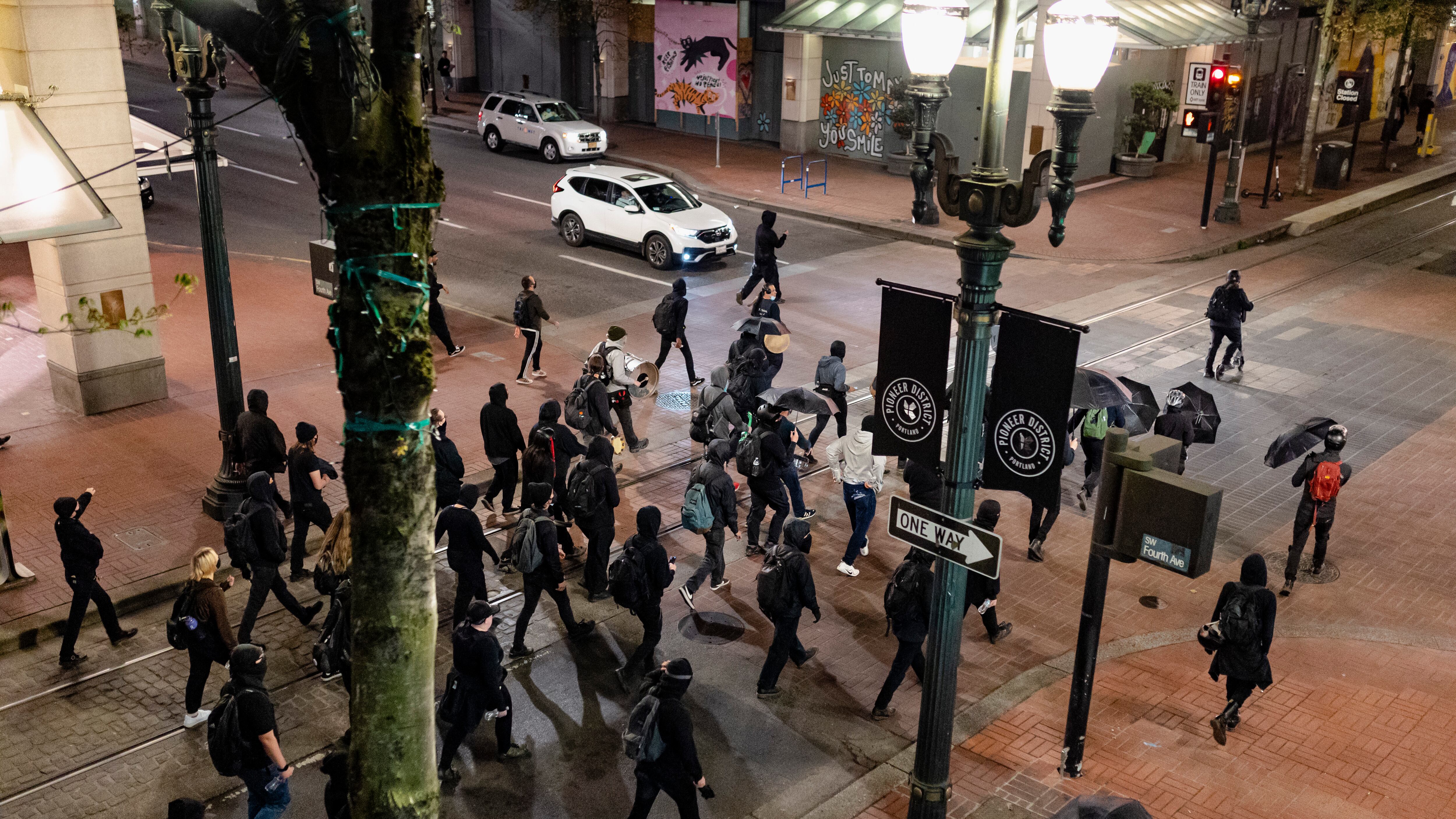 Protesters clad in black march in the street.