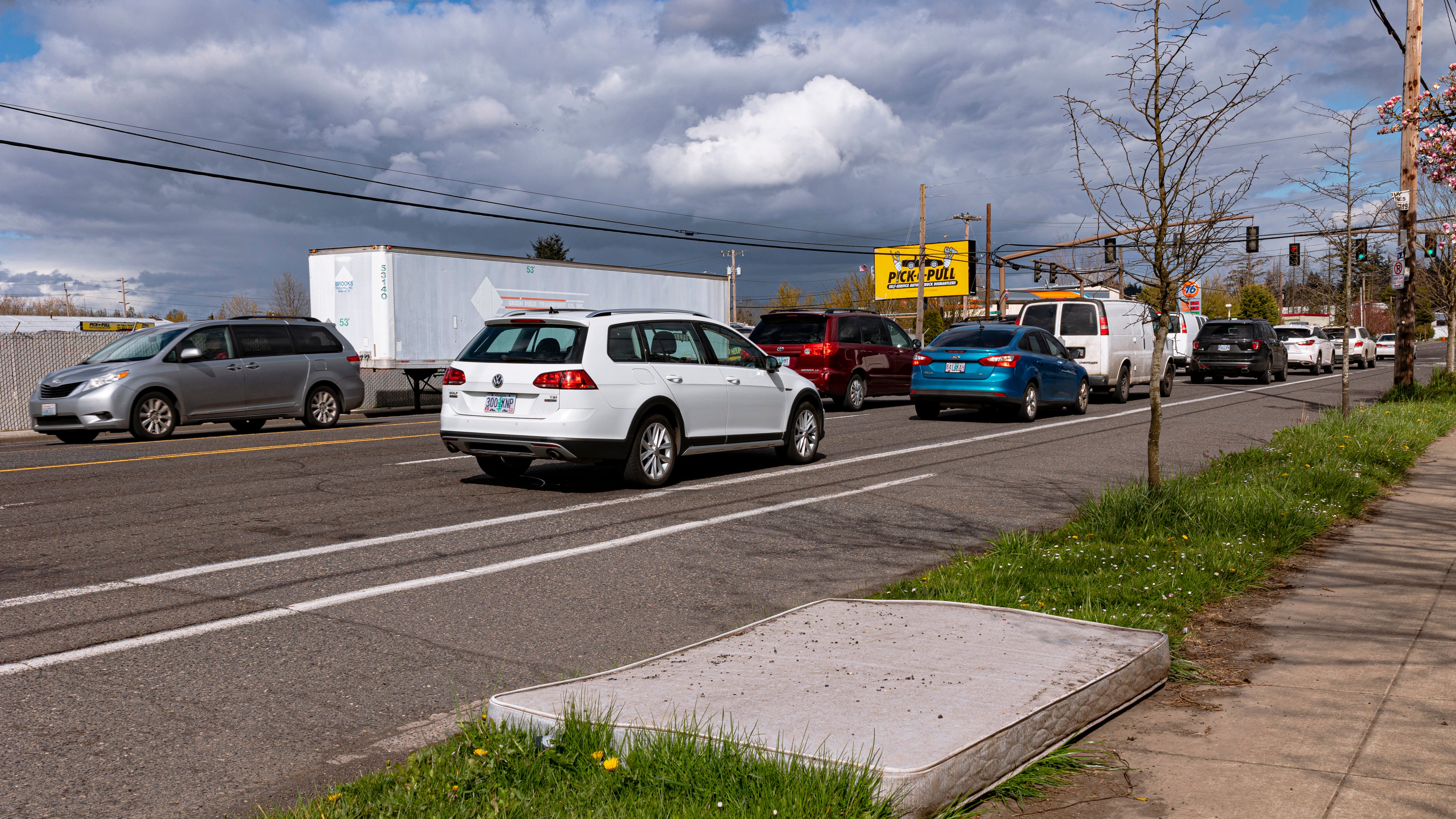 A mattress beside the sidewalk.