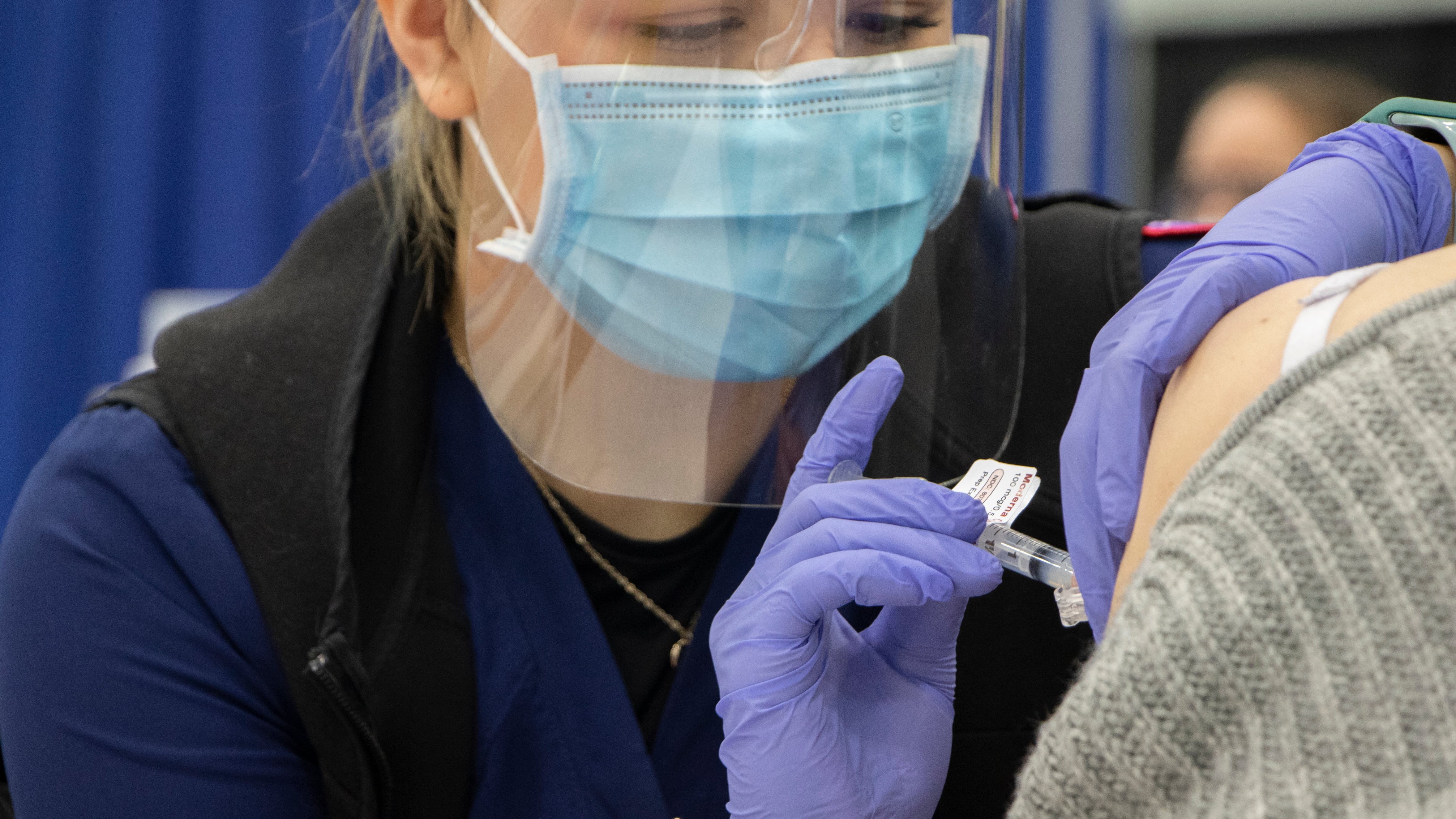 Nurse gives vaccine shot.